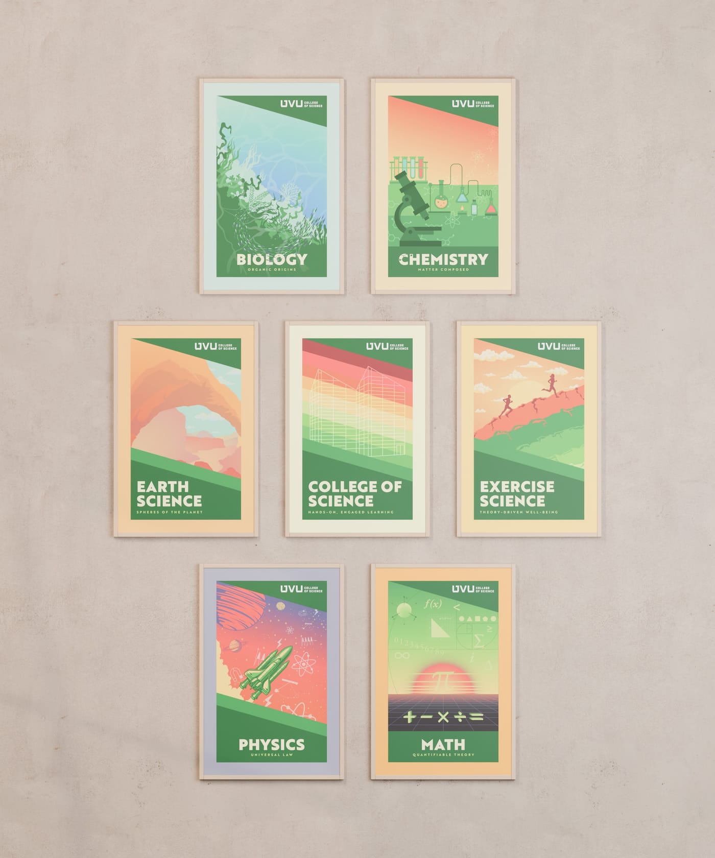 All seven College of Science posters in slim oak frames hung head-on in a two-three-two cluster on a warm plaster wall.