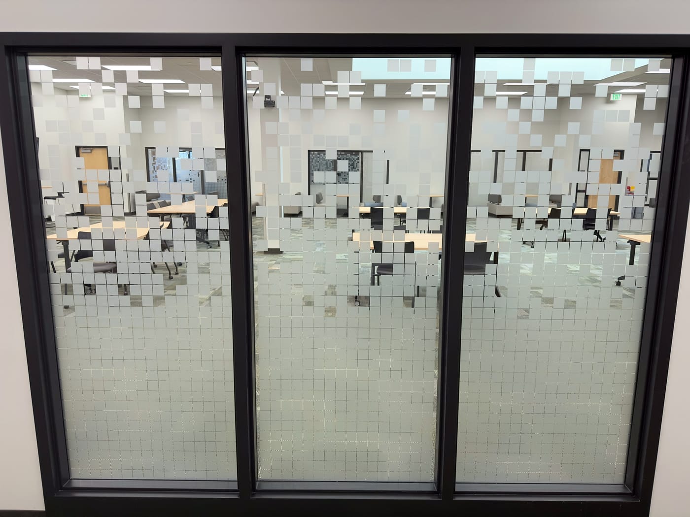 Glass doors with frosted vinyl squares that dissolve from dense to sparse.