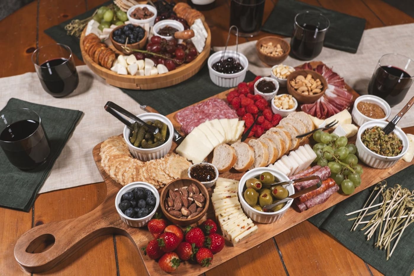 An overhead charcuterie board with cheeses, cured meats, berries and olives.