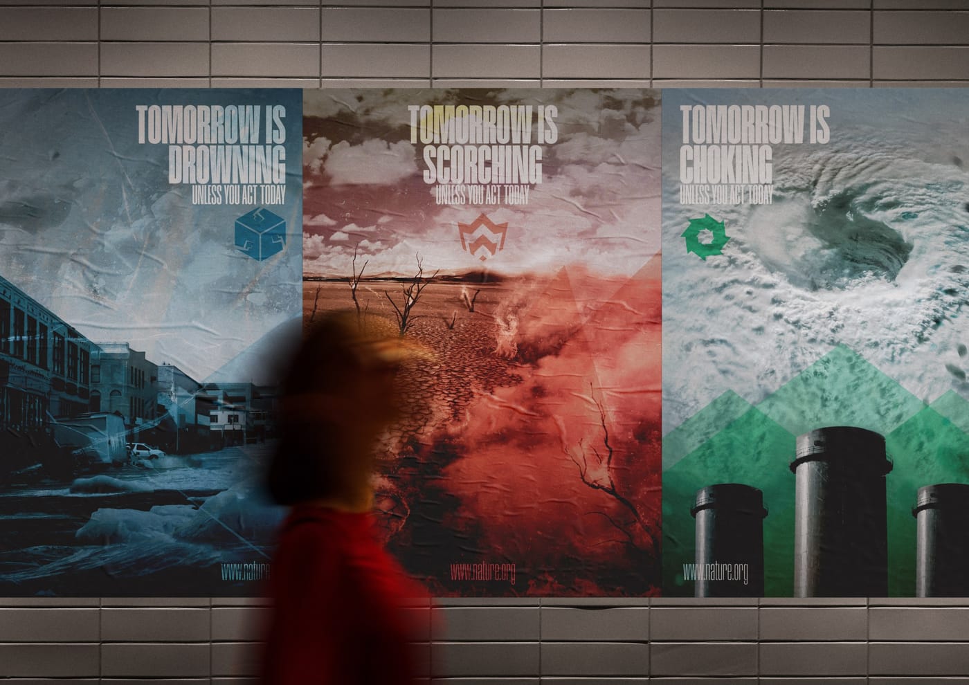 The posters wheat-pasted on a tiled wall, with a person walking past in motion blur.
